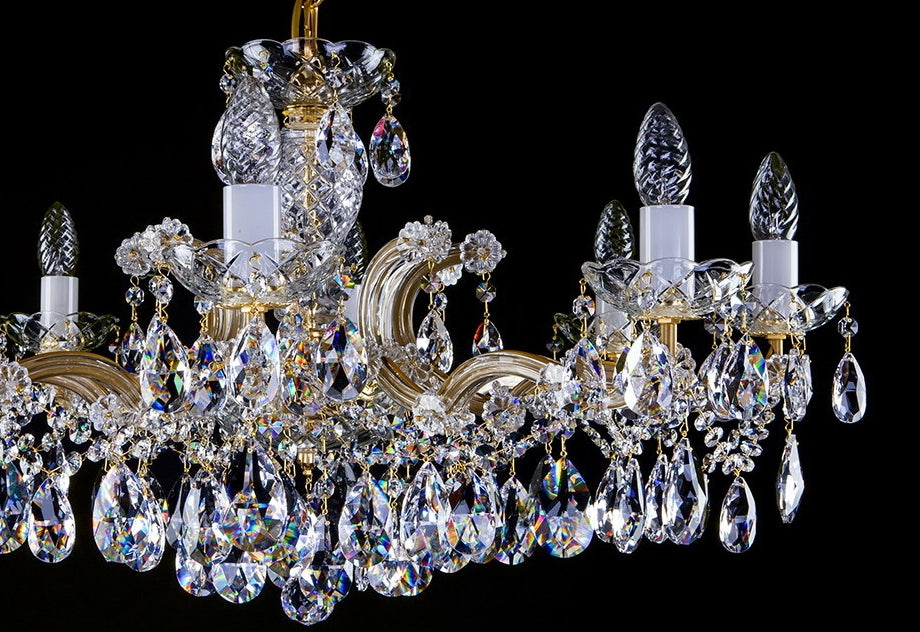 Vue de trois quarts du lustre doré et de ses grappes de cristal