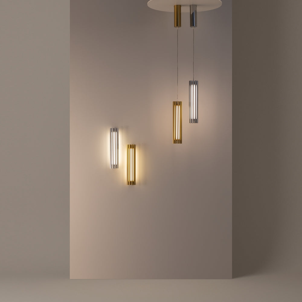 Mise en ambiance avec appliques et suspensions dorées et argentées sur mur gris