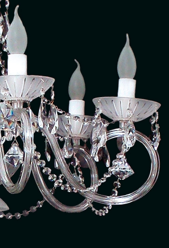Détail des bobèches, douilles et pendants de cristal sur les bras du luminaire.