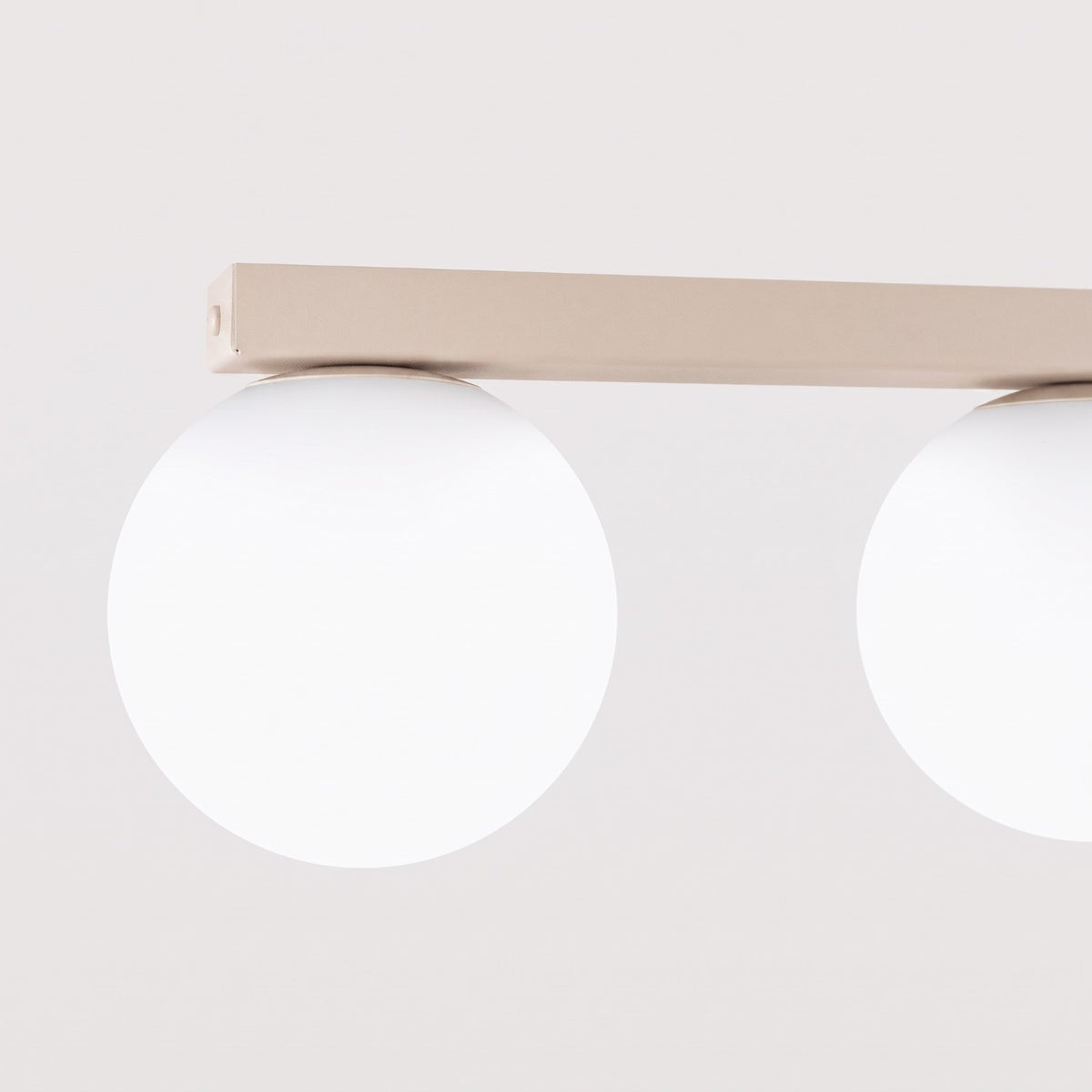 Vue rapprochée de la structure rectangulaire beige et des deux globes de gauche