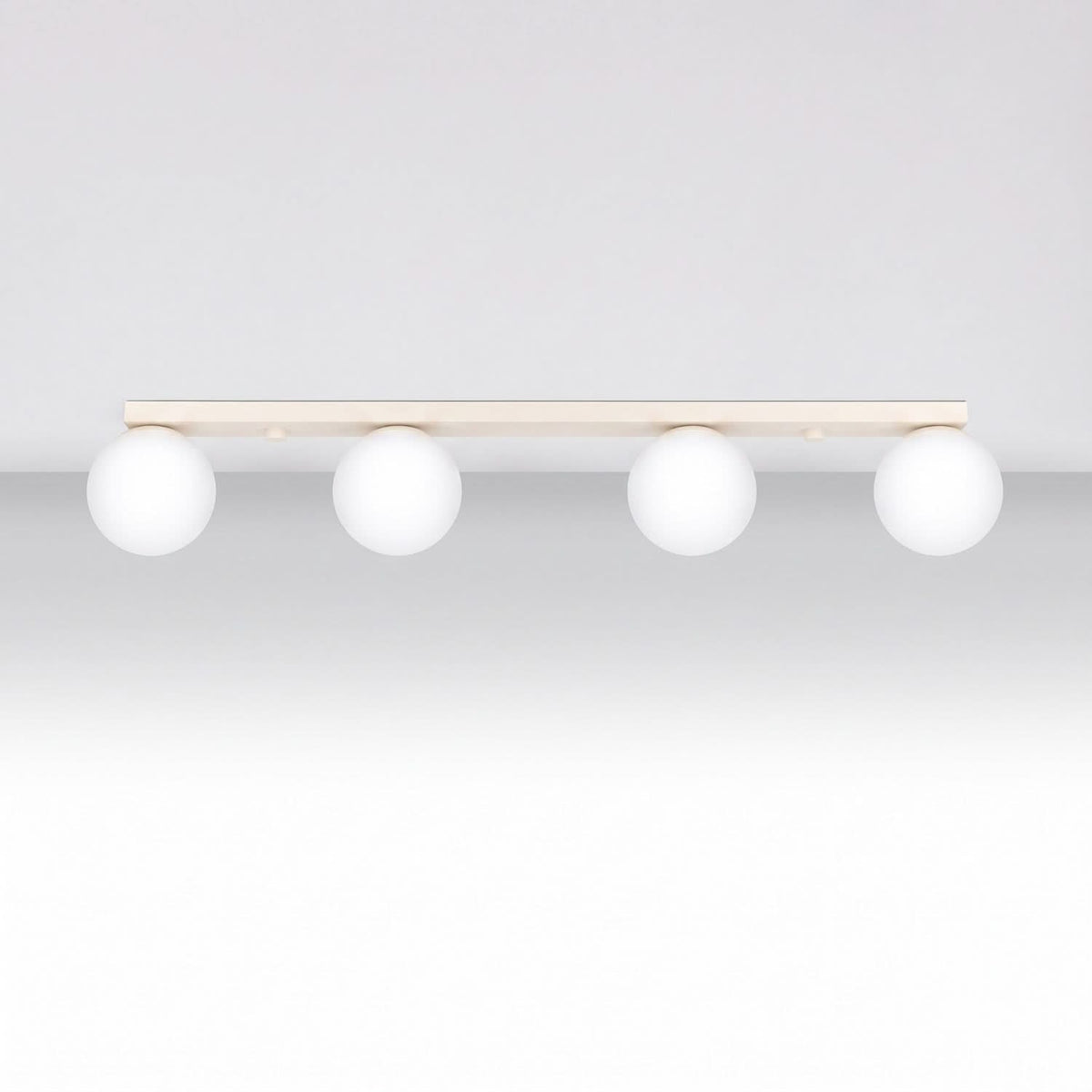 Plafonnier blanc fixé au plafond, quatre globes lumineux alignés horizontalement.