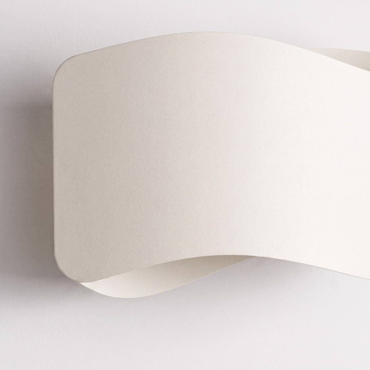 Détail rapproché de la finition mate texturée et du coin arrondi du diffuseur.