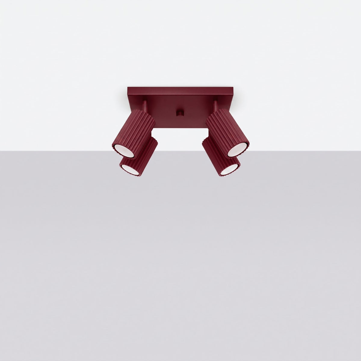 Luminaire plafonnier rouge bordeaux installé au plafond, vue légèrement en contre-plongée.