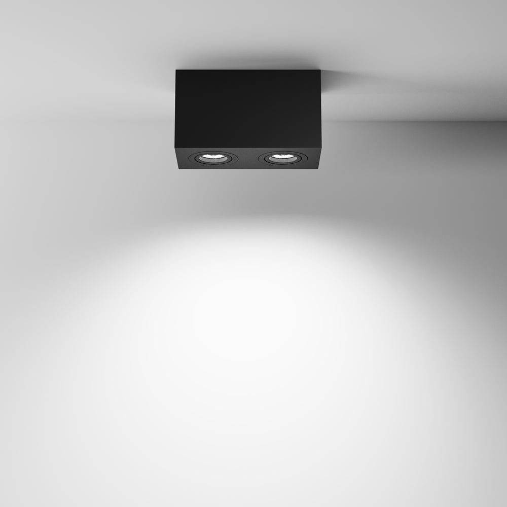 Luminaire fixé au plafond blanc, halo de lumière projeté sur le mur