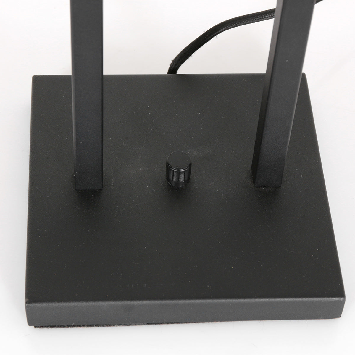 Vue rapprochée du socle rectangulaire noir avec interrupteur rotatif et cordon tressé.