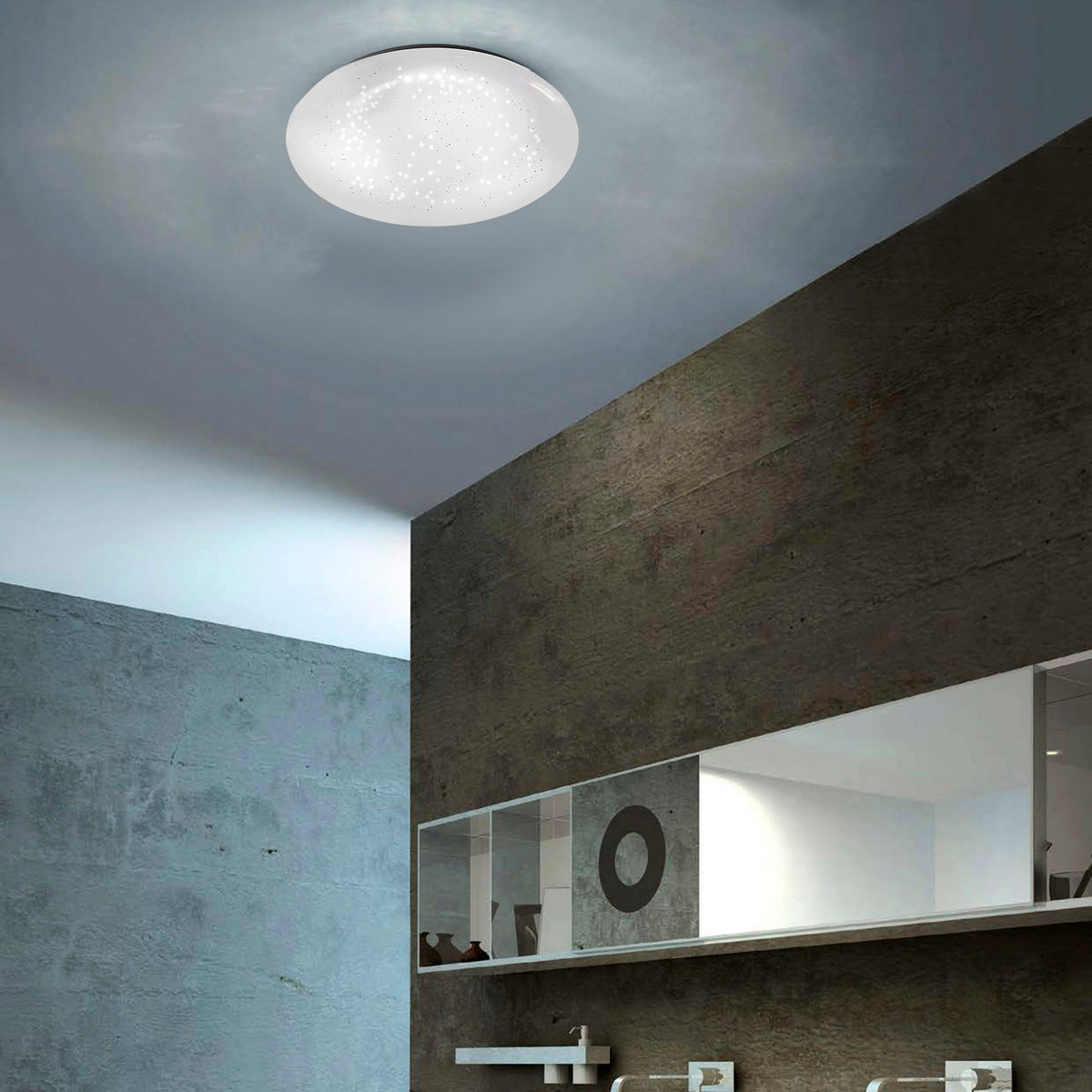 Mise en ambiance du plafonnier allumé dans une salle de bains aux murs béton et miroir.