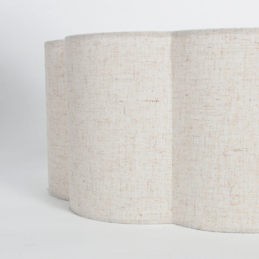 Gros plan sur la texture lin crème de l'abat-jour festonné.