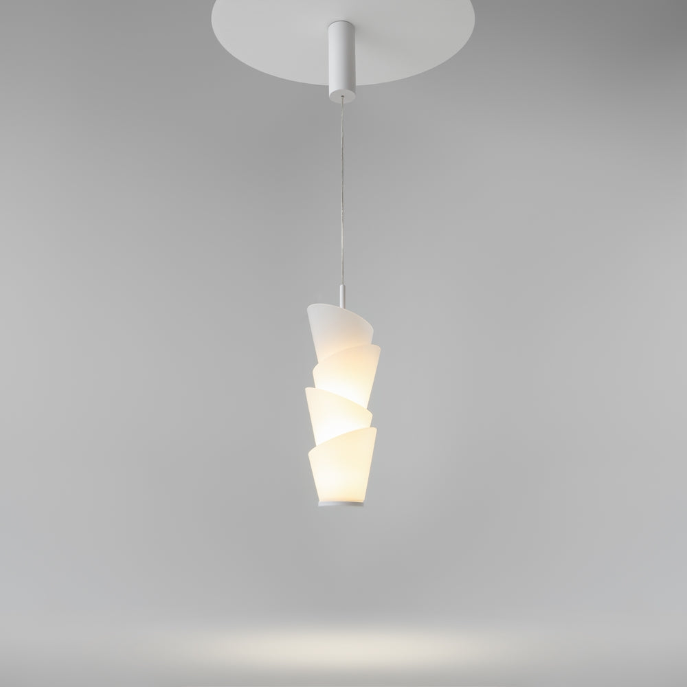 Suspension allumée sous plafond gris, rosace ronde et diffuseur conique lumineux.