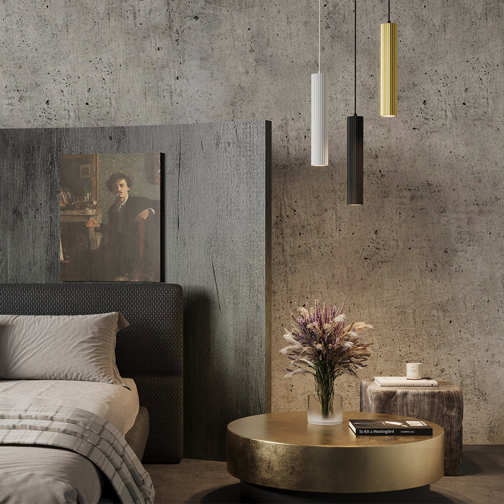 Mise en ambiance chambre béton avec trois suspensions dorée, noire et blanche