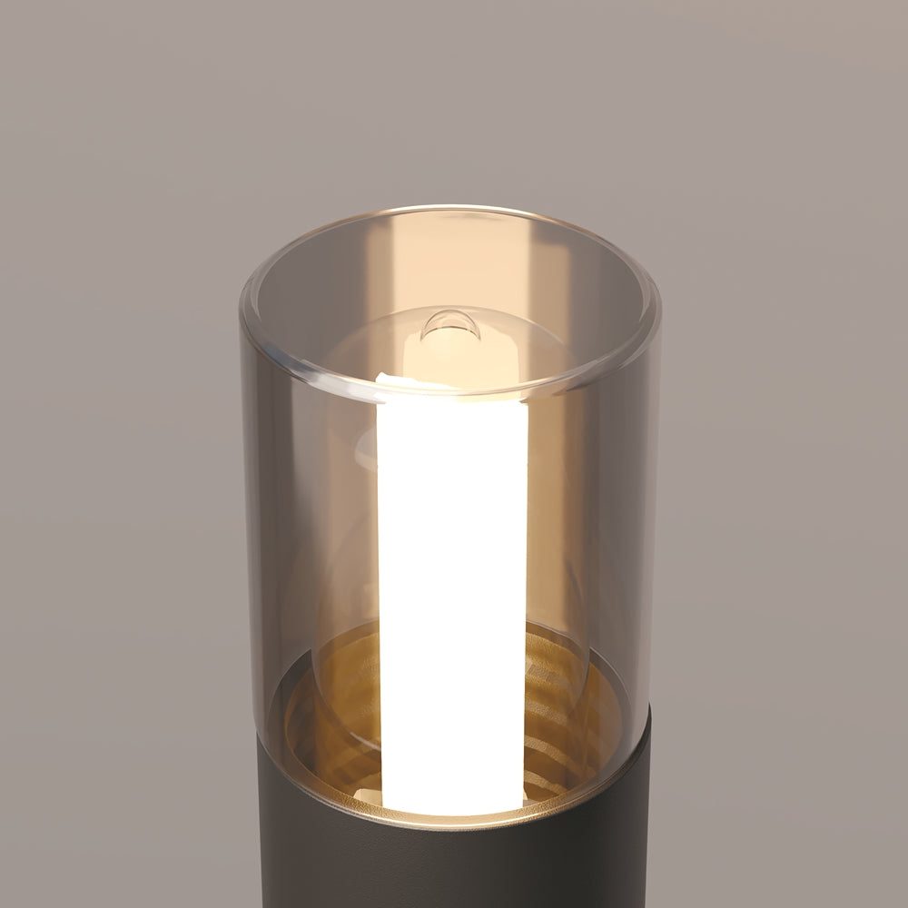Vue rapprochée du cylindre lumineux avec lumière chaude et reflets dorés.