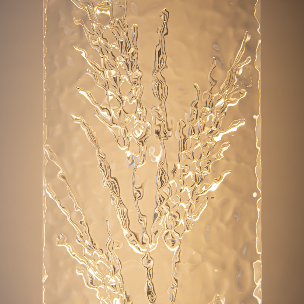 Gros plan sur le verre martelé et les épis de blé en relief rétroéclairés.