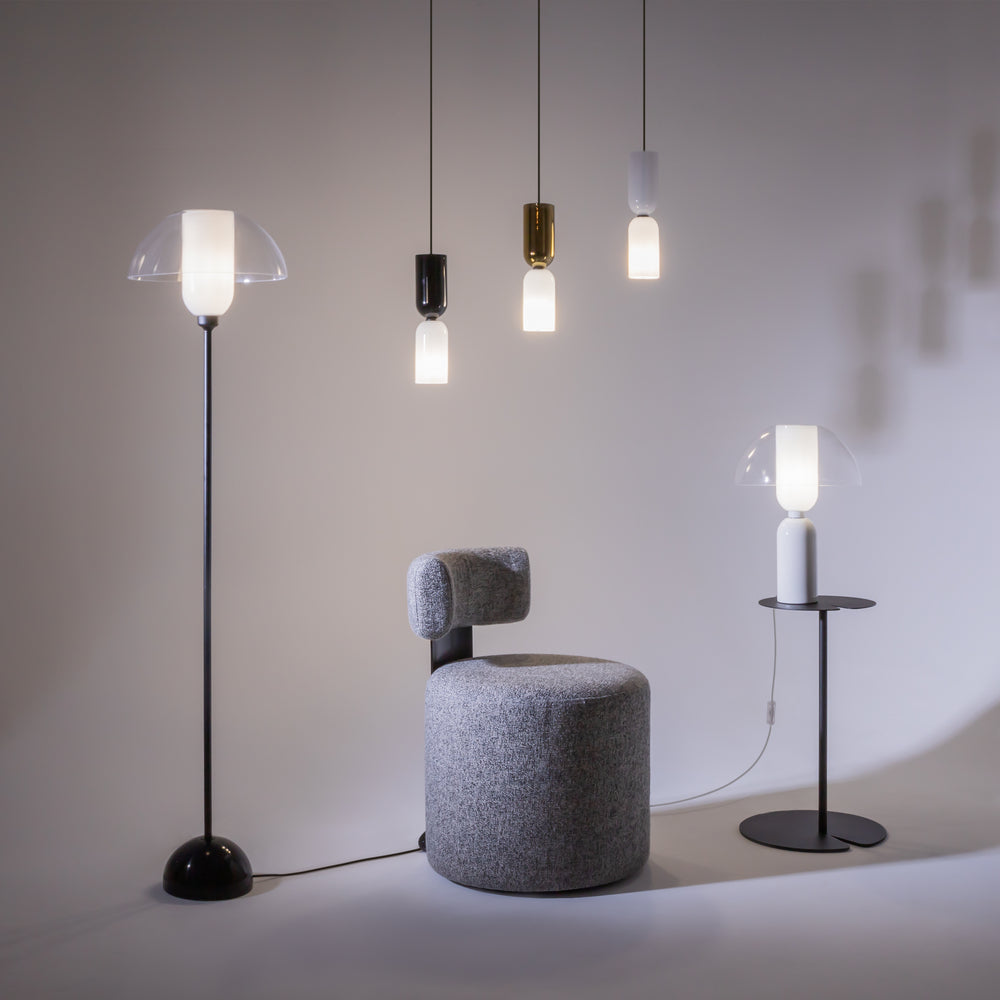 Mise en ambiance avec suspensions, lampadaire et lampe à poser dans un intérieur gris