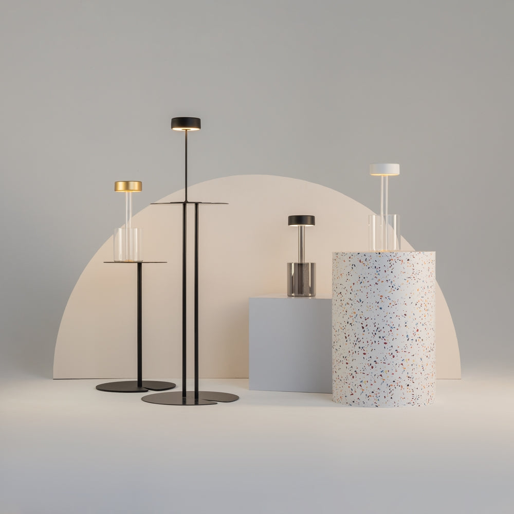 Collection de lampes aux finitions variées présentées sur des socles géométriques