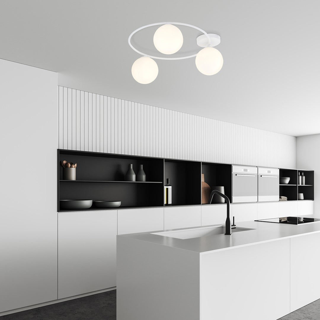 Plafonnier allumé trônant au-dessus d'un îlot de cuisine blanche moderne