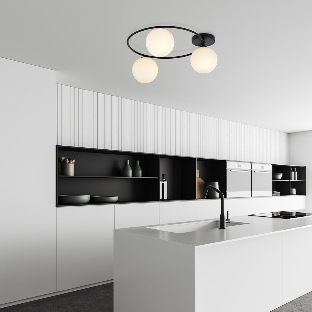 Mise en ambiance dans une cuisine blanche, plafonnier allumé au-dessus du plan de travail