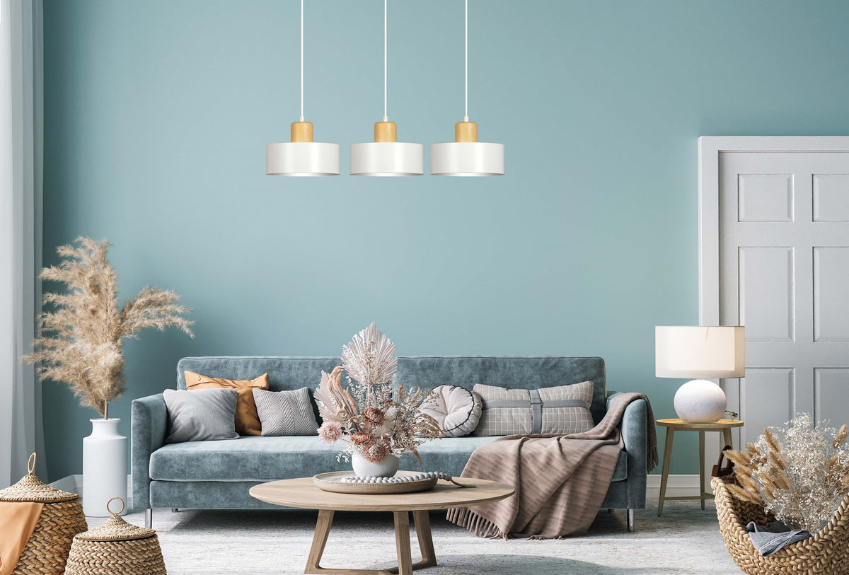 Mise en ambiance salon bleu pastel avec suspension triples abat-jours blancs au plafond