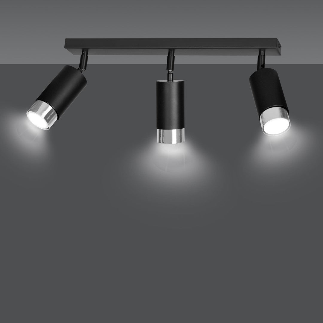Plafonnier allumé projetant trois cônes de lumière blanche sur fond gris anthracite.