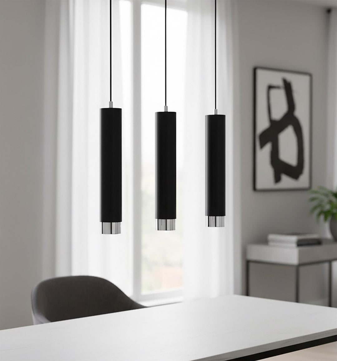 Gros plan des trois cylindres noirs devant une fenêtre voilée, intérieur épuré