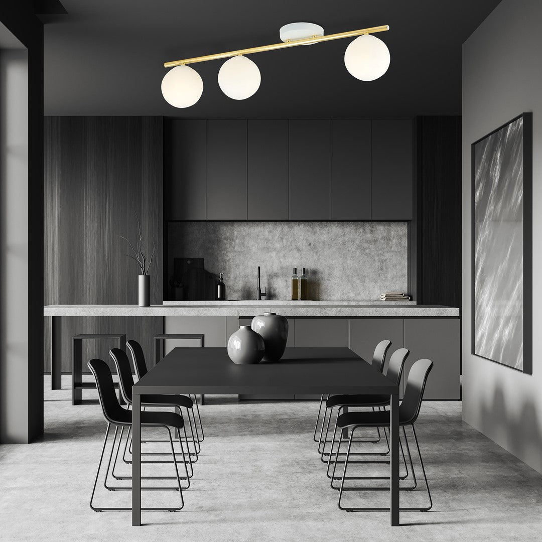 Ambiance salle à manger sombre avec le plafonnier trois globes éclairé au-dessus de la table.
