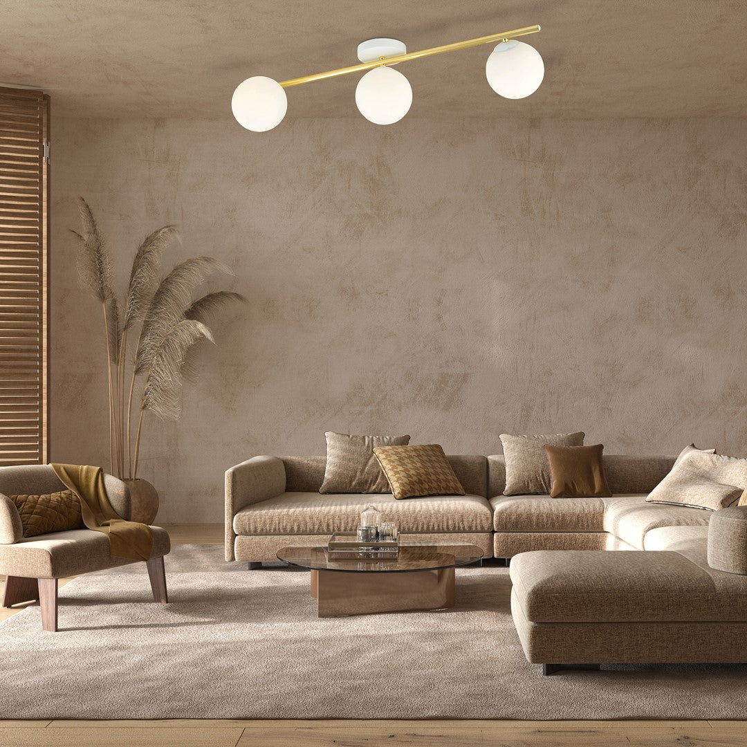 Mise en ambiance salon beige, trois globes lumineux éclairant un canapé et une table