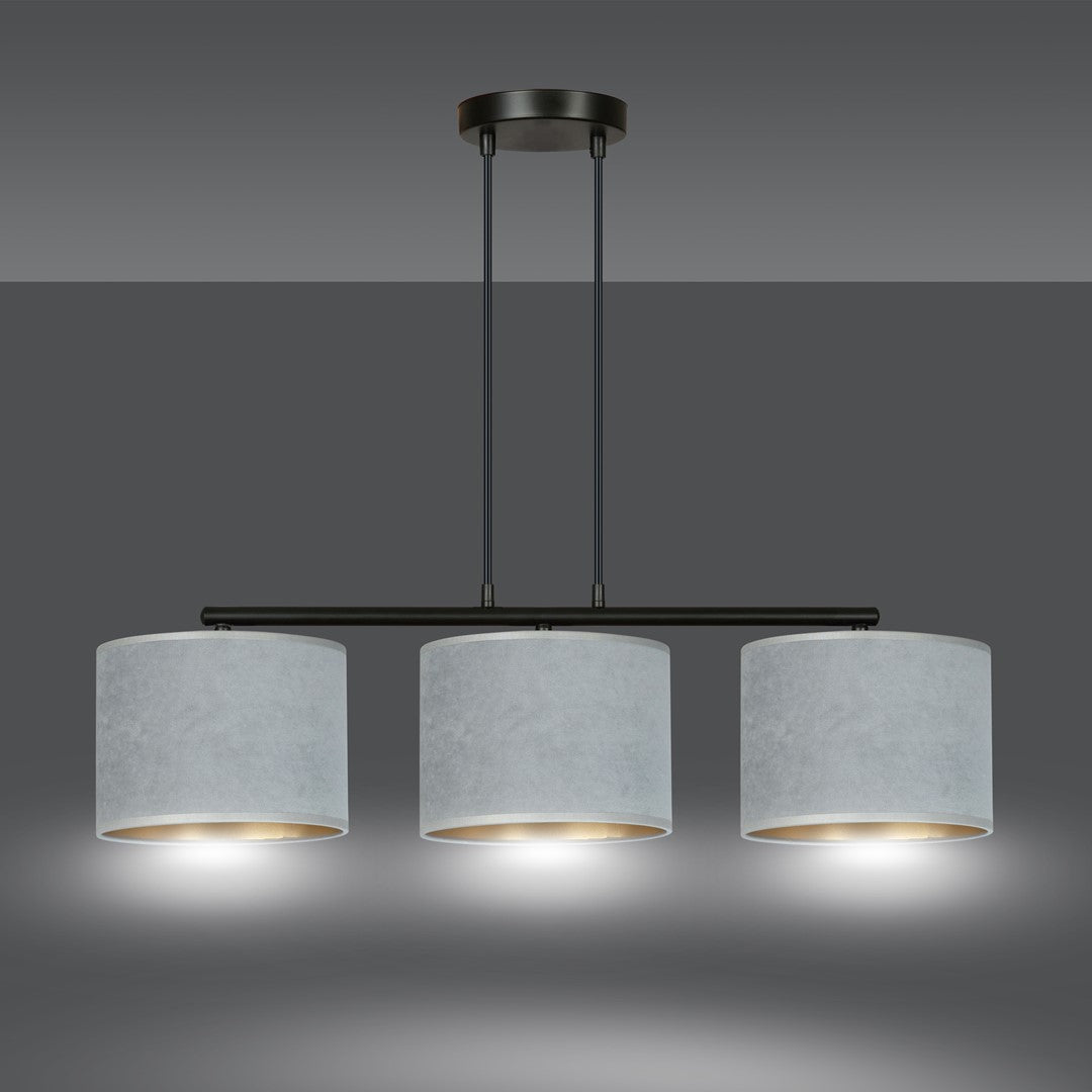 Luminaire allumé, halo lumineux doré diffusé sous chaque abat-jour