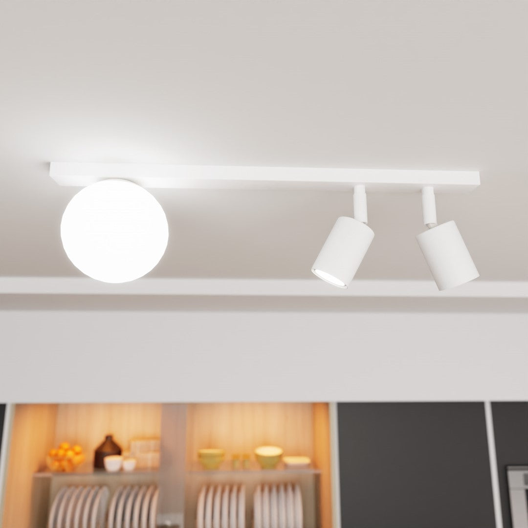 Gros plan du luminaire allumé au plafond, barre blanche et spots inclinés