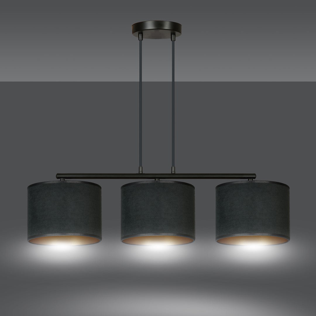 Même suspension allumée, trois halos de lumière chaude sous les abat-jours