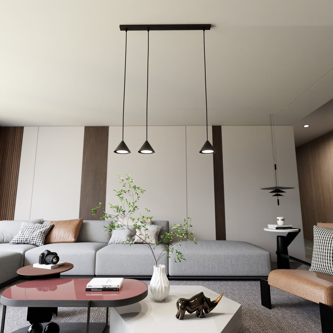 Mise en ambiance dans un salon gris, luminaire suspendu au-dessus du canapé d'angle