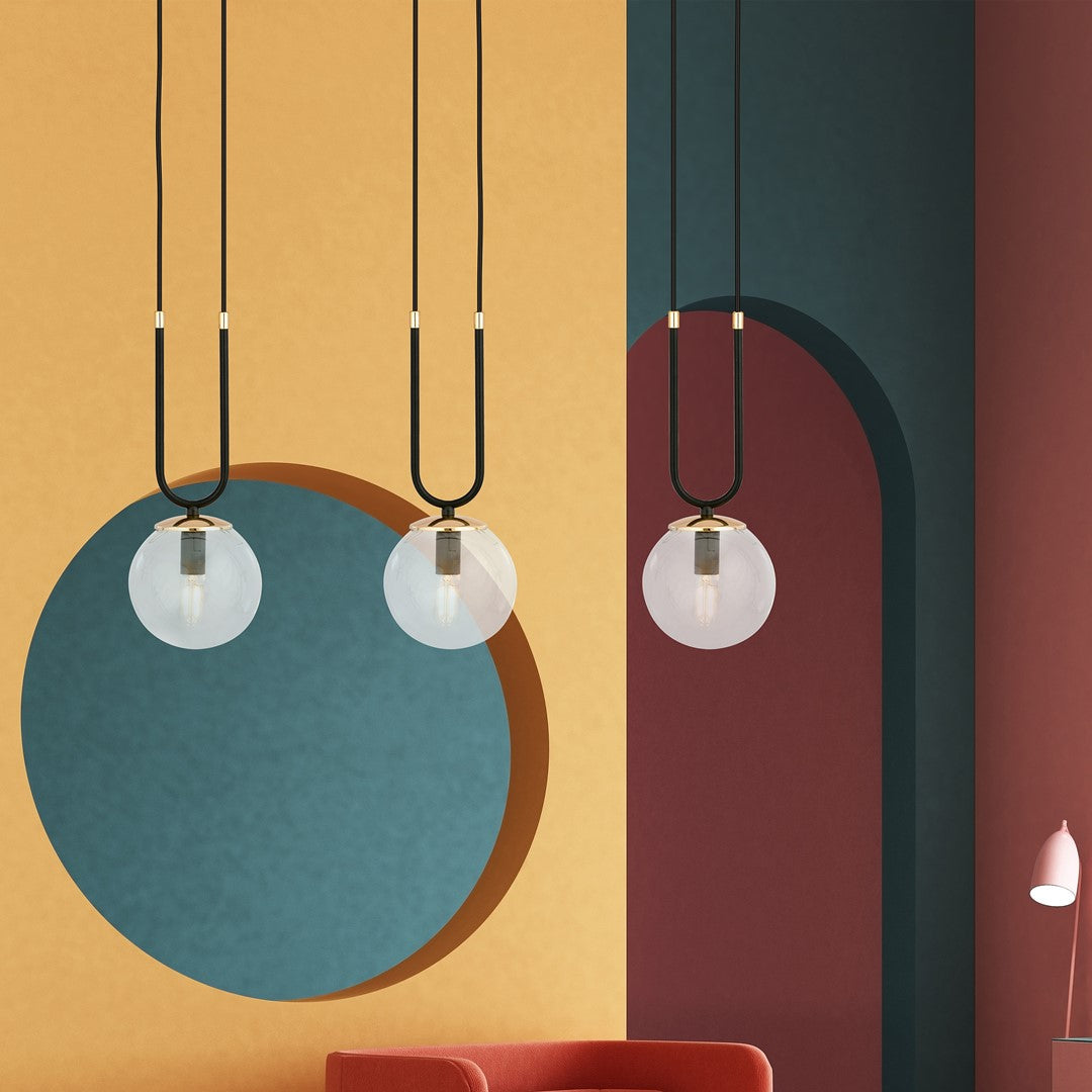 Suspension installée devant des murs colorés jaune, bleu et bordeaux, décor moderne