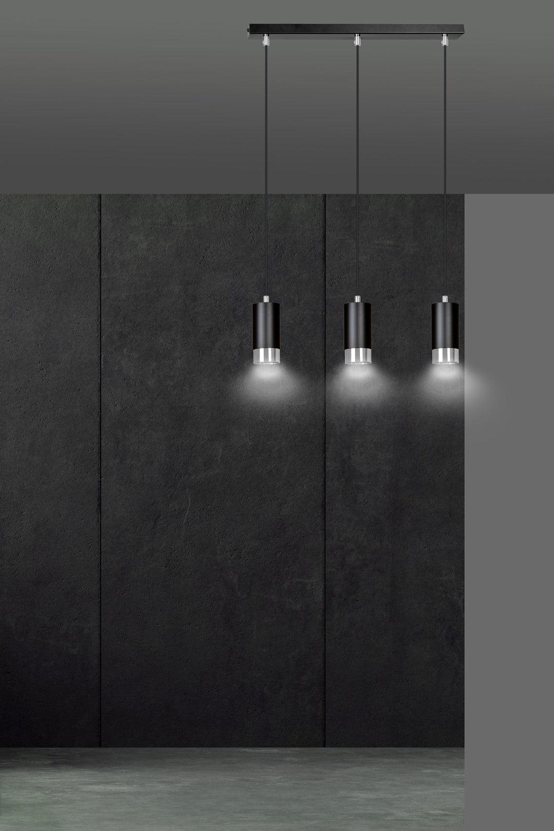 Mise en ambiance sur mur sombre, trois abat-jours cylindriques noirs allumés
