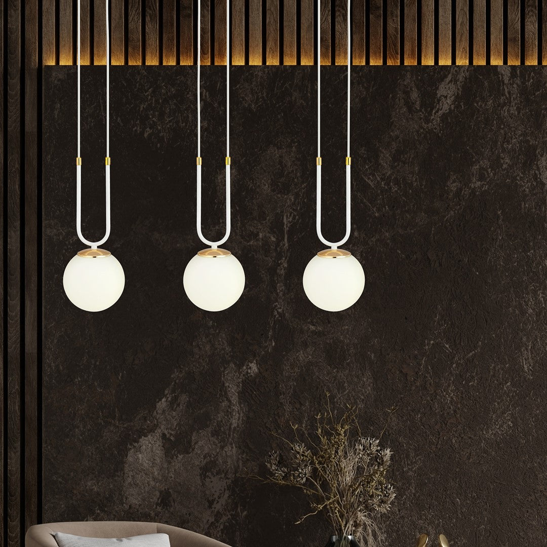 Ambiance sombre avec mur texturé, les trois globes opale allumés au-dessus.