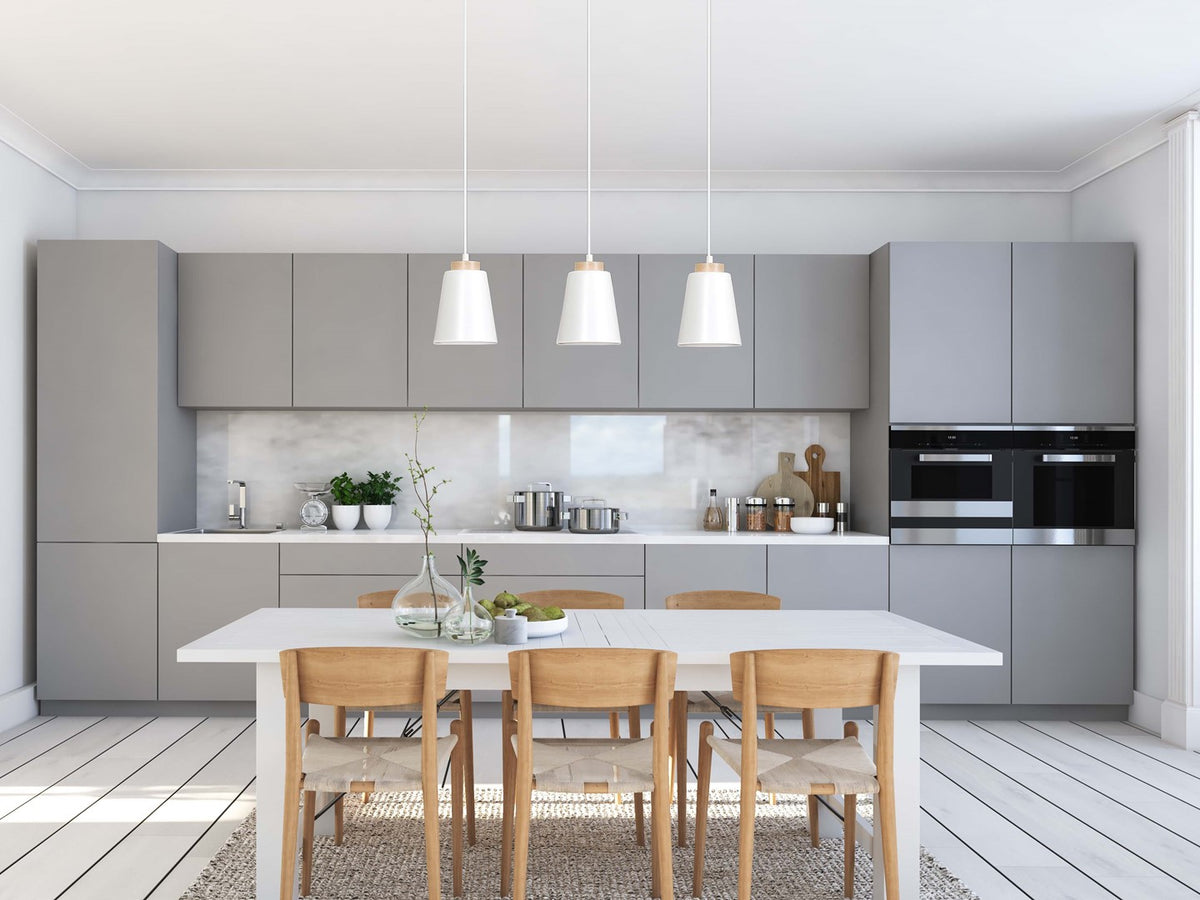 Mise en ambiance cuisine grise : les trois suspensions alignées au-dessus d'une table blanche