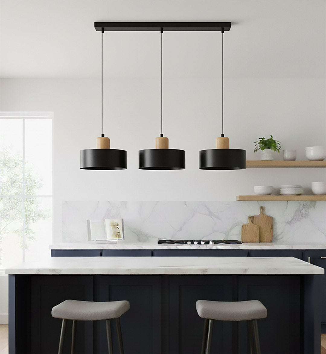 Ambiance cuisine contemporaine avec îlot bleu nuit en marbre, suspension alignée au-dessus.