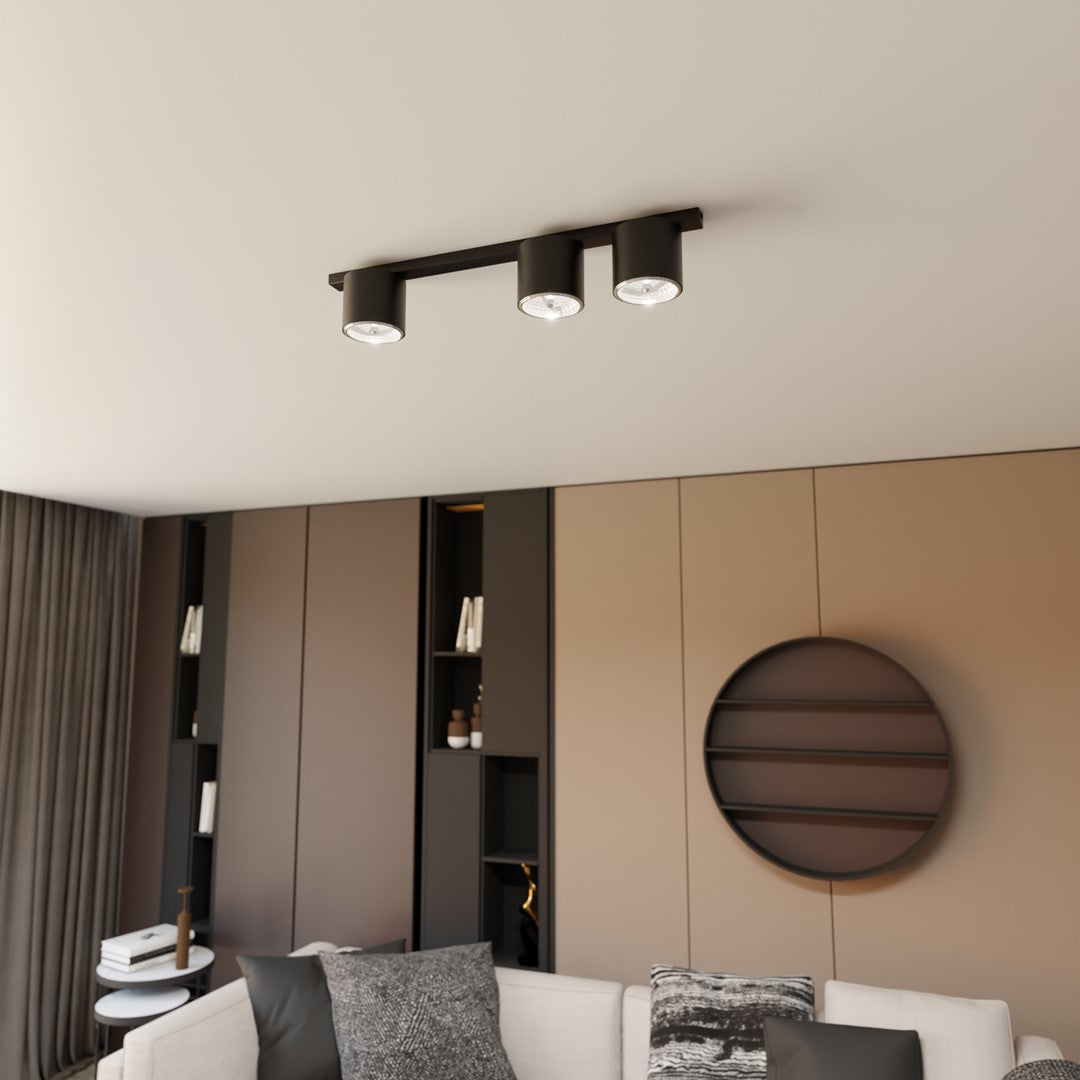 Mise en ambiance dans un salon moderne avec le plafonnier noir allumé au plafond.