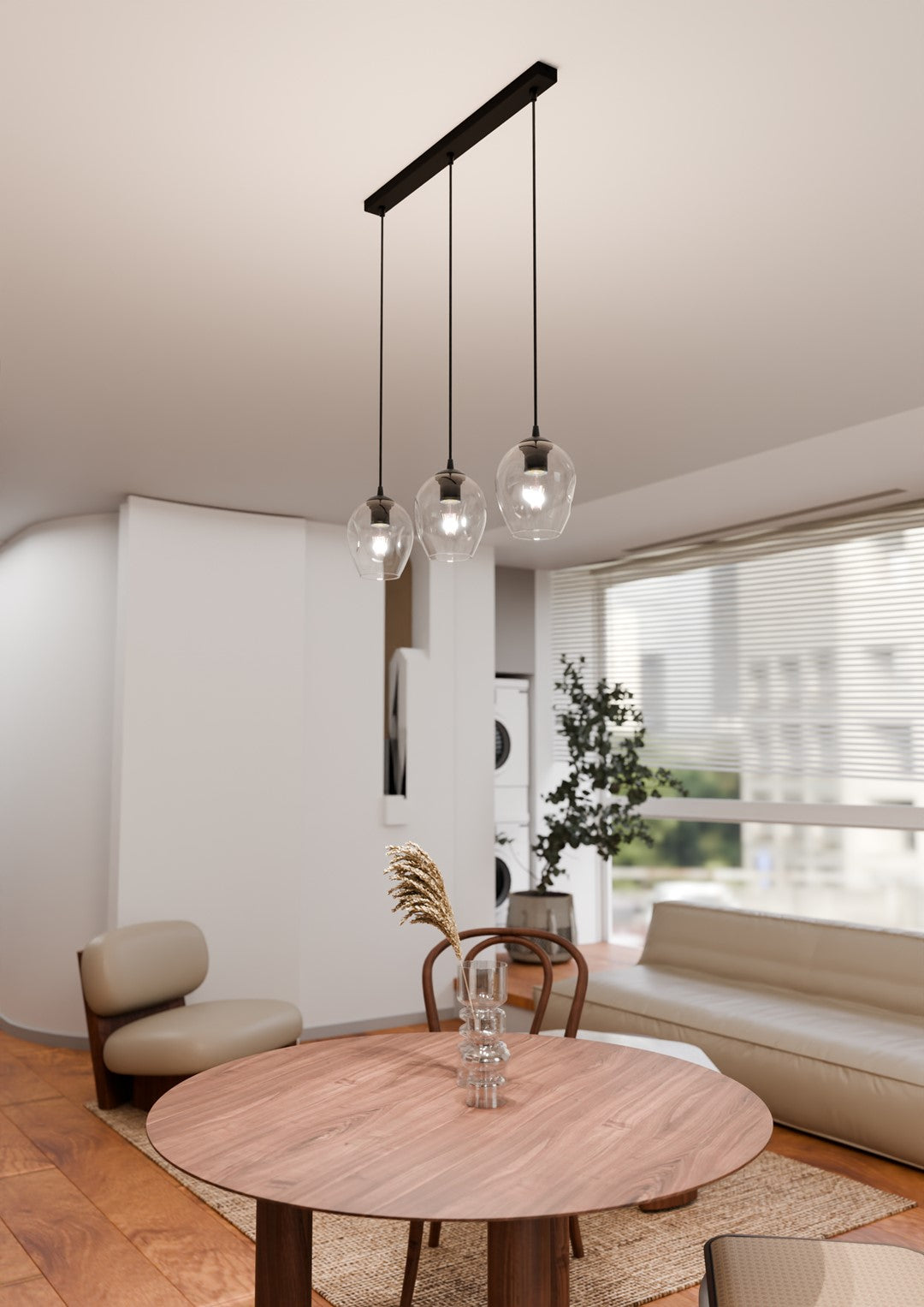 Mise en ambiance coin repas, suspension au-dessus d'une table ronde en bois clair.