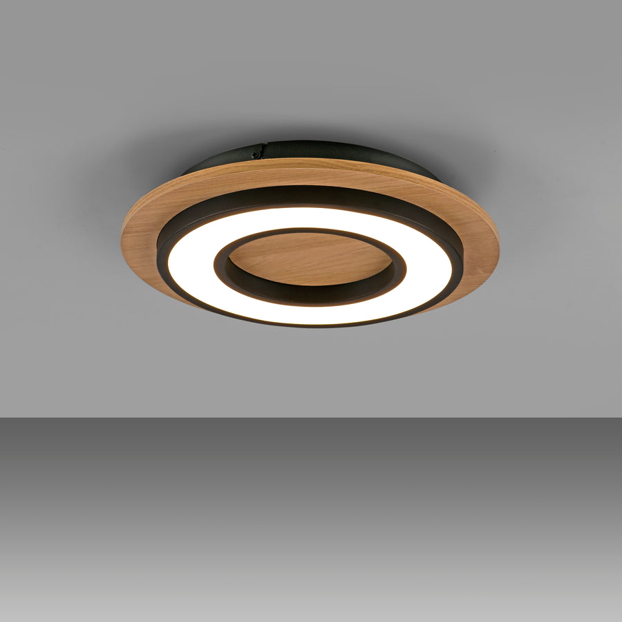 Vue plongeante du plafonnier allumé projetant un halo lumineux sur fond gris