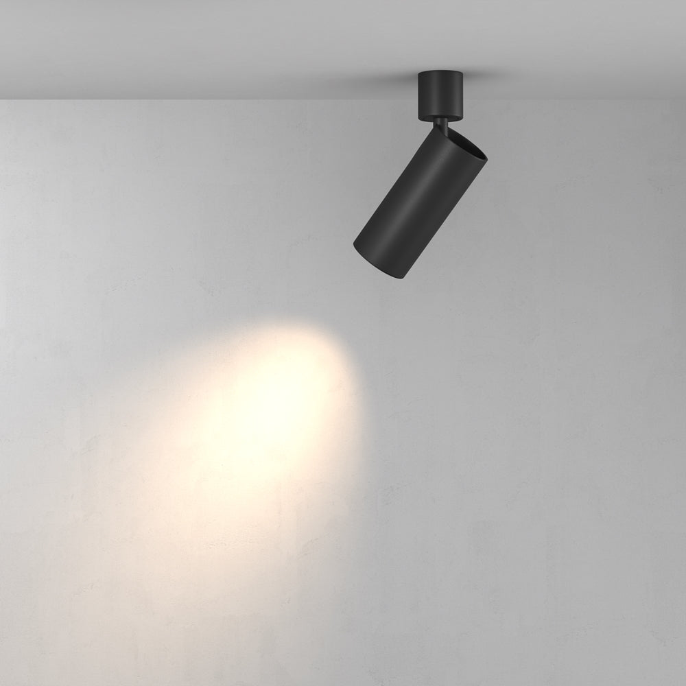 Spot incliné vers un mur, projetant un halo de lumière chaude