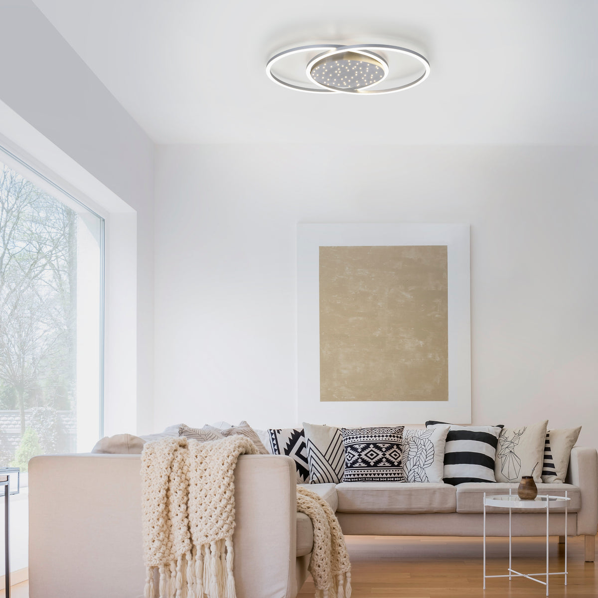 Mise en ambiance du plafonnier allumé dans un salon au canapé beige