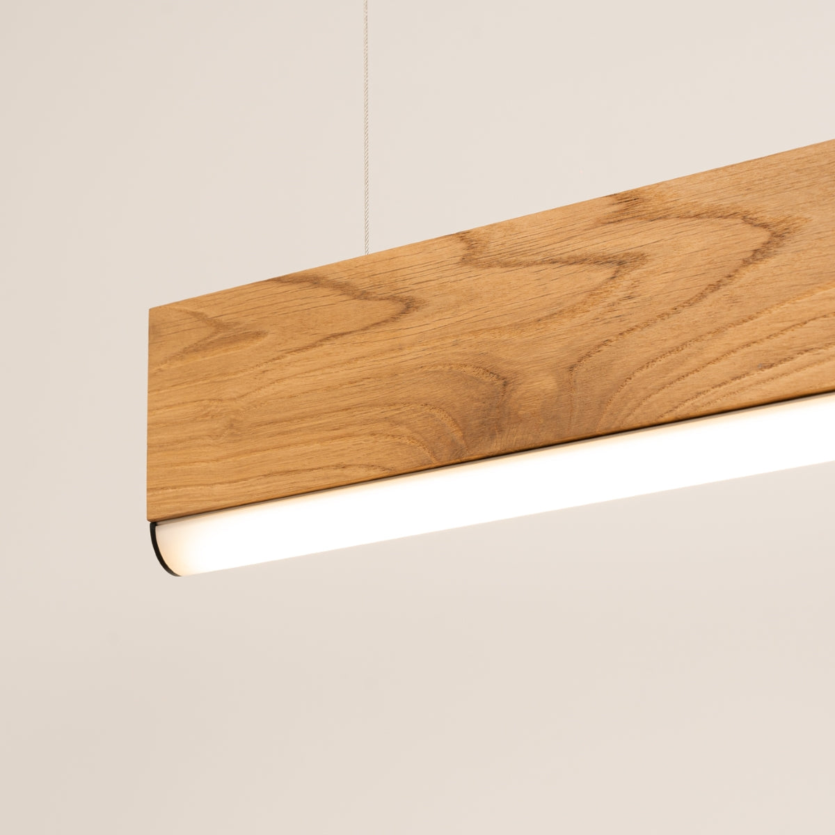 Gros plan sur le bois verni et le diffuseur LED blanc en dessous.