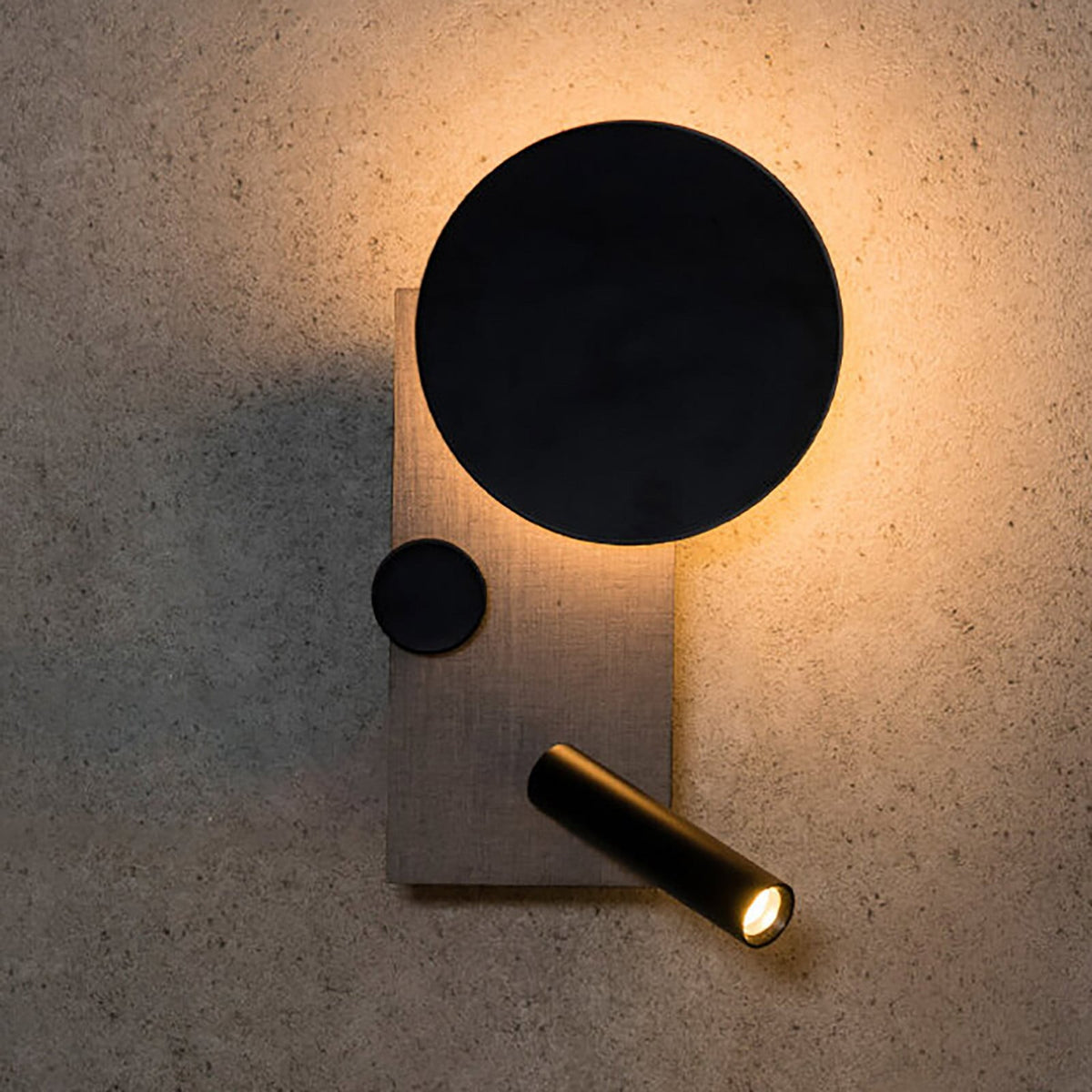 Applique murale grise et noire allumée sur un mur texturé beige