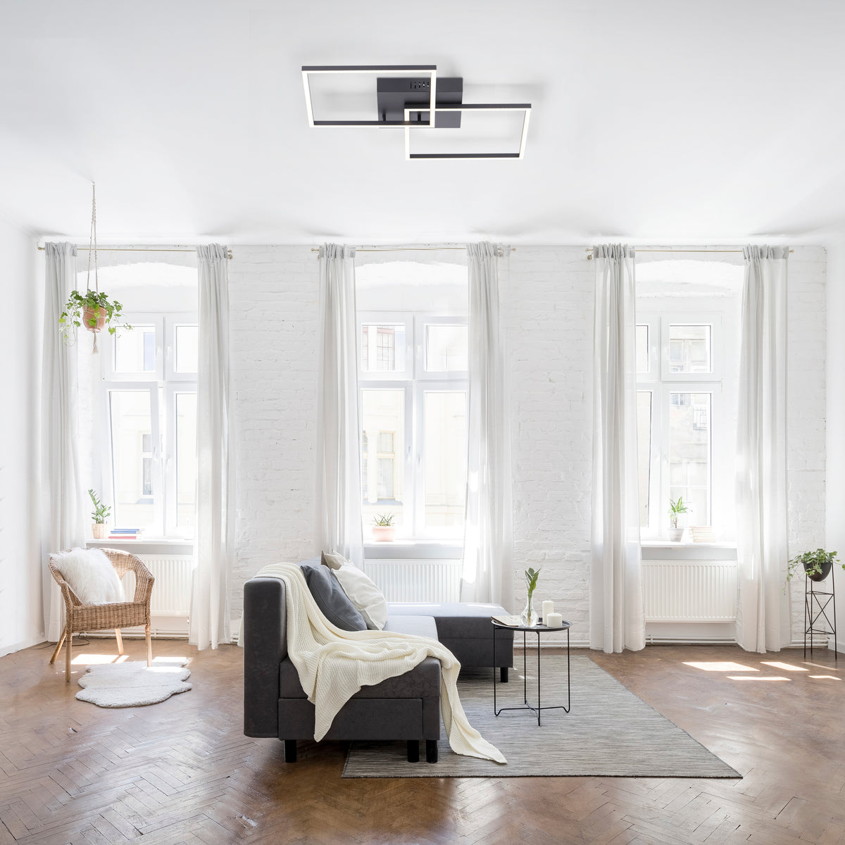 Mise en ambiance du plafonnier allumé dans un salon blanc très lumineux