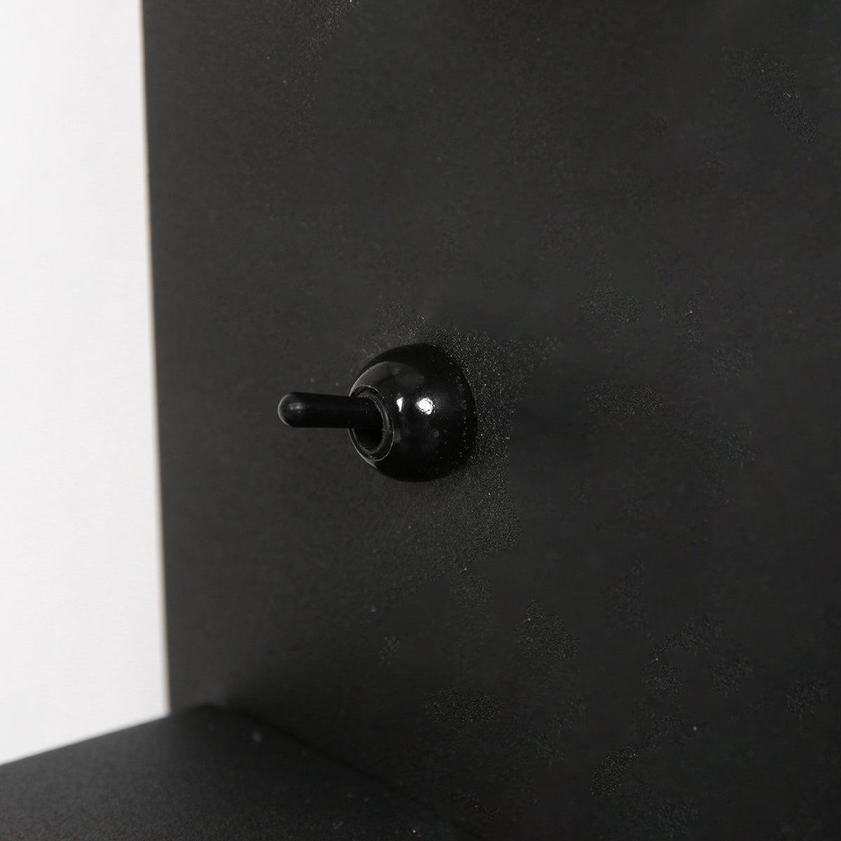 Gros plan de l'interrupteur à bascule noir situé sur la platine murale