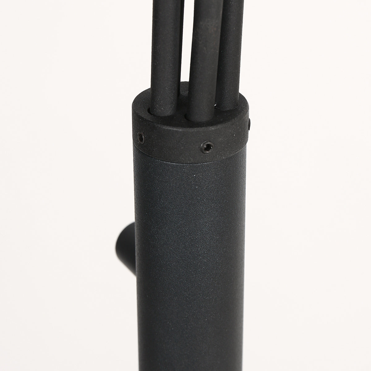 Gros plan sur le fût cylindrique noir et le collier où s'insèrent les cinq tubes