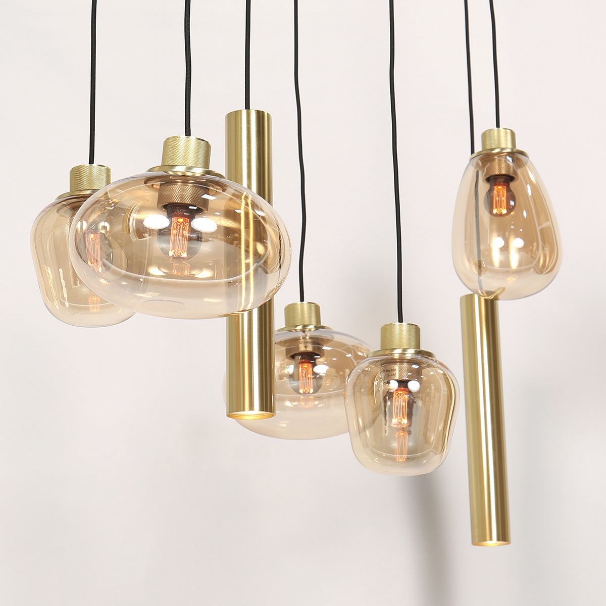 Détail des globes en verre ambré et des spots tubes laiton de la suspension Reflexa