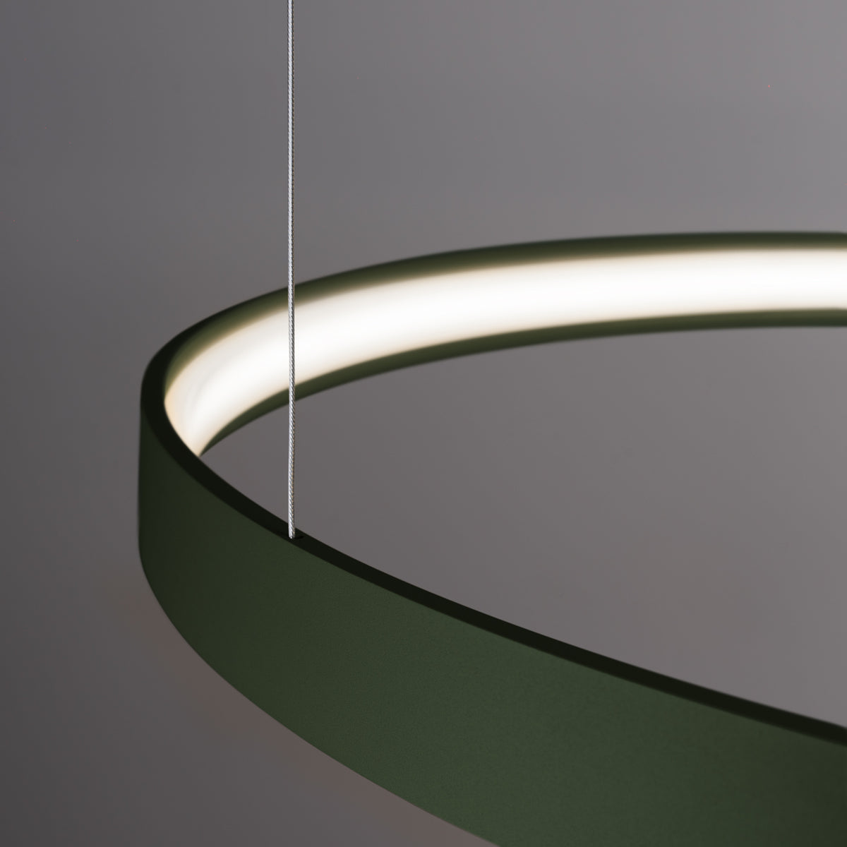 Détail rapproché d'un anneau vert et de son câble, ruban LED allumé visible.