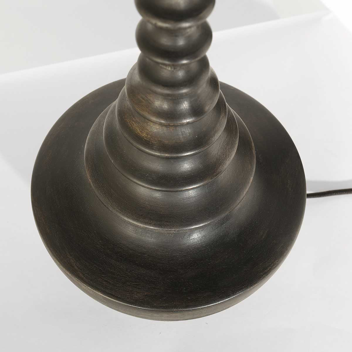 Détail de la base circulaire en bois noir-brun aux anneaux tournés superposés