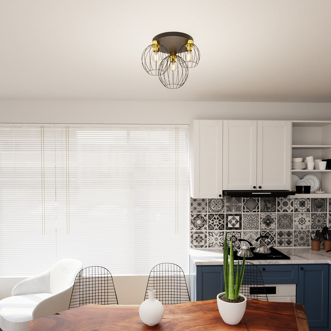 Suspension trois lumières installée au plafond au-dessus d'une table dans une cuisine moderne.