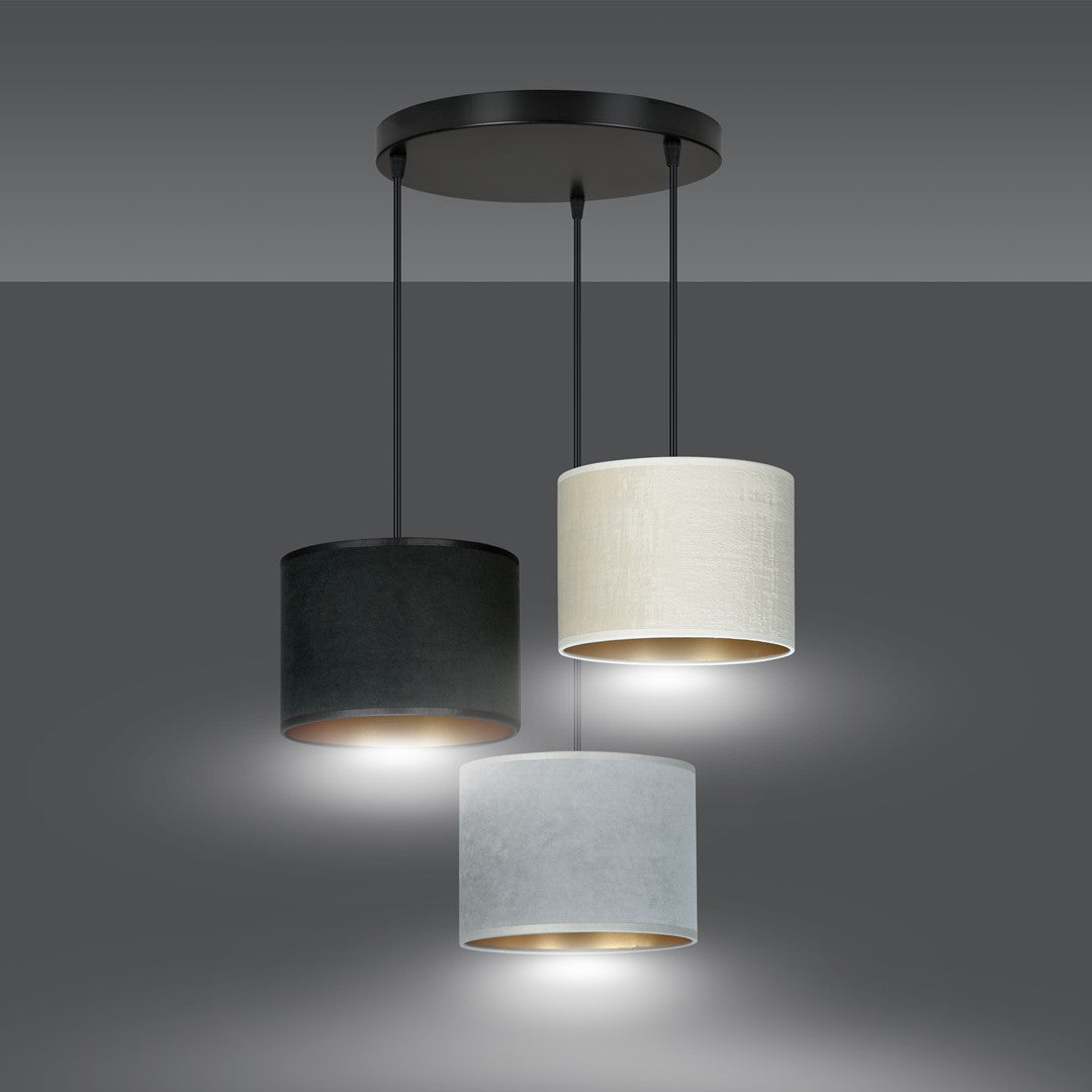 Luminaire allumé sur fond gris, halos lumineux diffusés sous chaque abat-jour textile