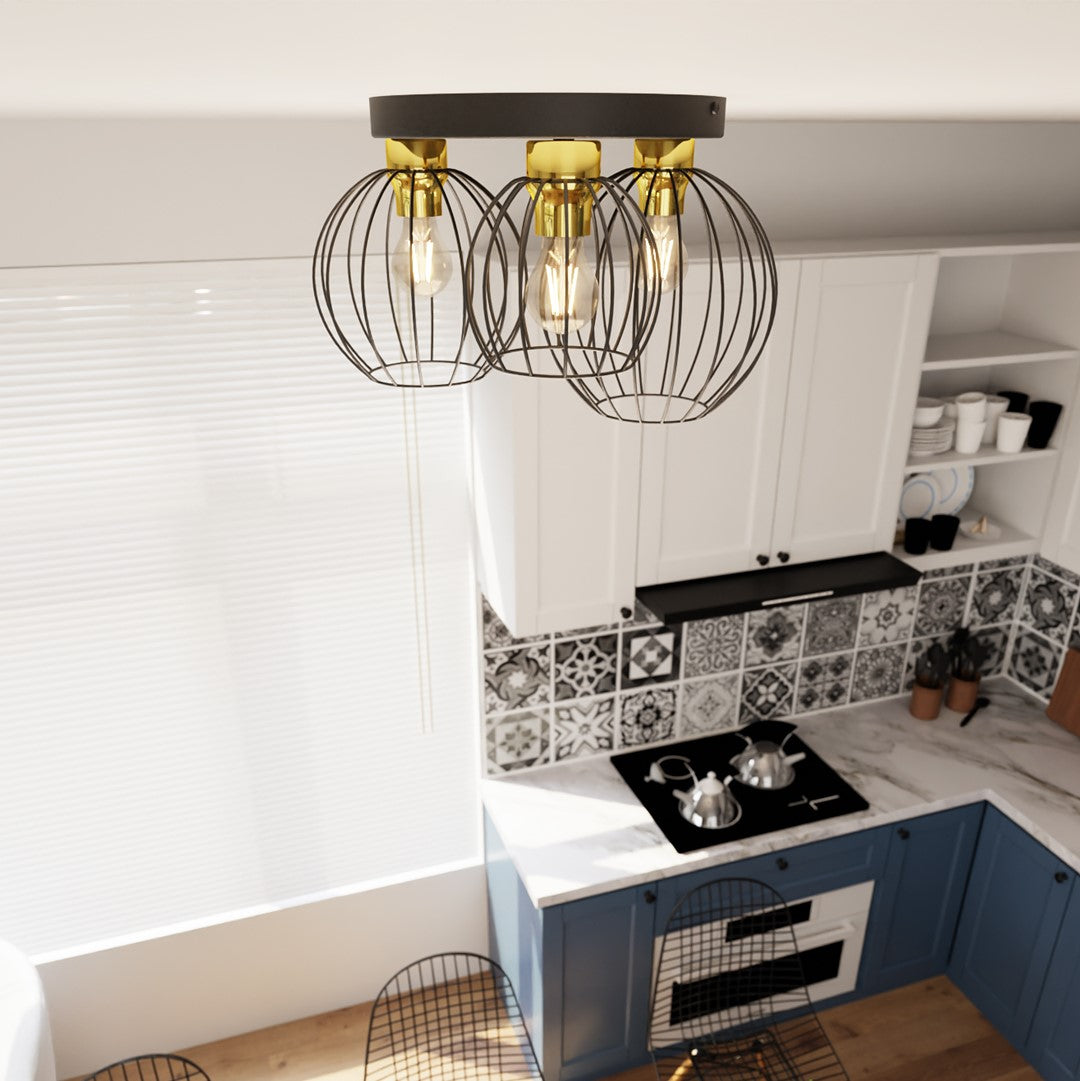 Gros plan sur les trois cages métalliques noires et les ampoules allumées du luminaire.
