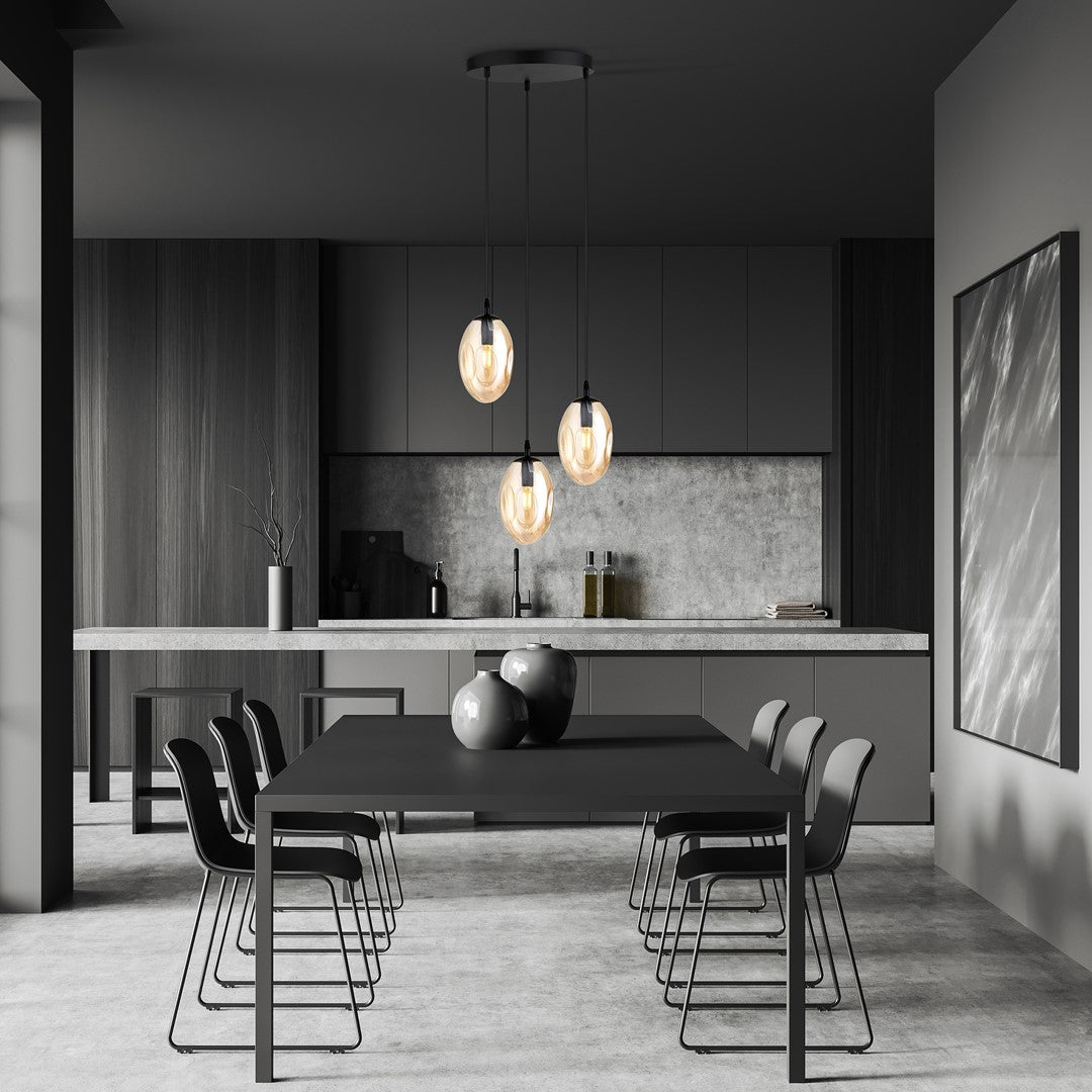 Ambiance cuisine sombre, trois globes ambrés éclairant une grande table à manger